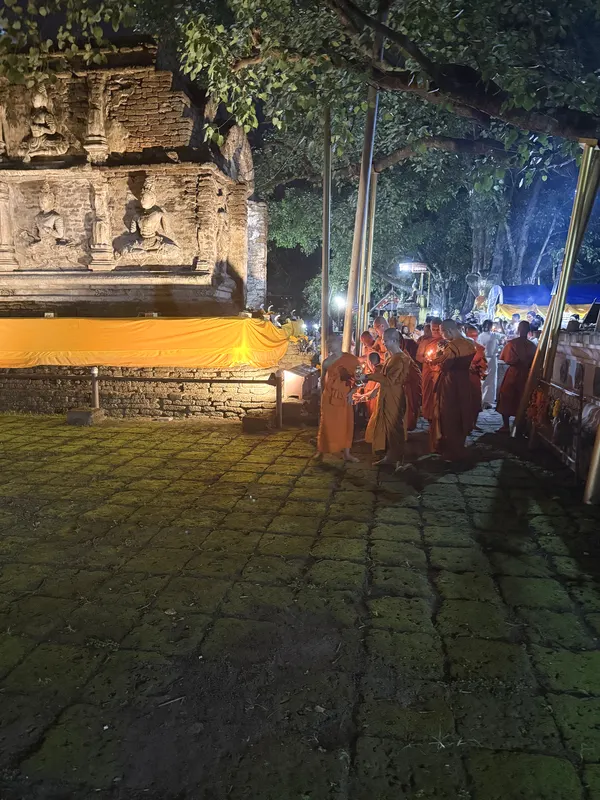 The wian tian procession of monks moving alongside the Maha Chedi at Wat Jed Yod, with a saffron cloth wrapped around the base